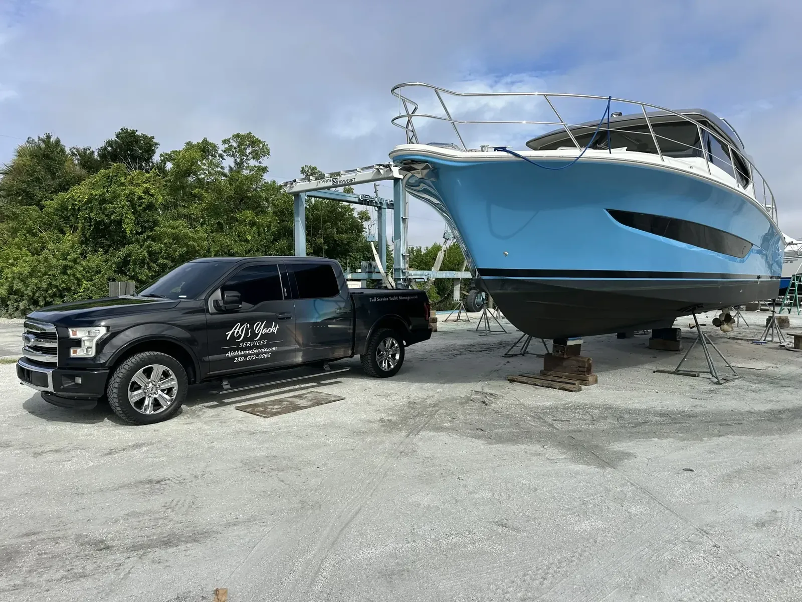 AJYS truck beside a yacht in the yard
